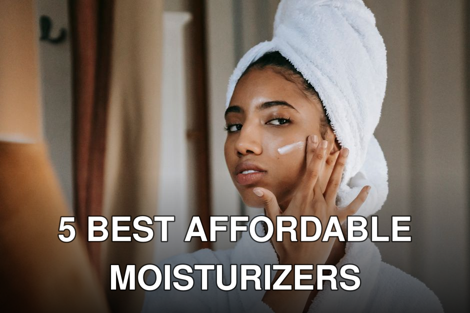 Young attentive ethnic female in bathrobe applying smear of moisturizing cream on face while looking in mirror at home