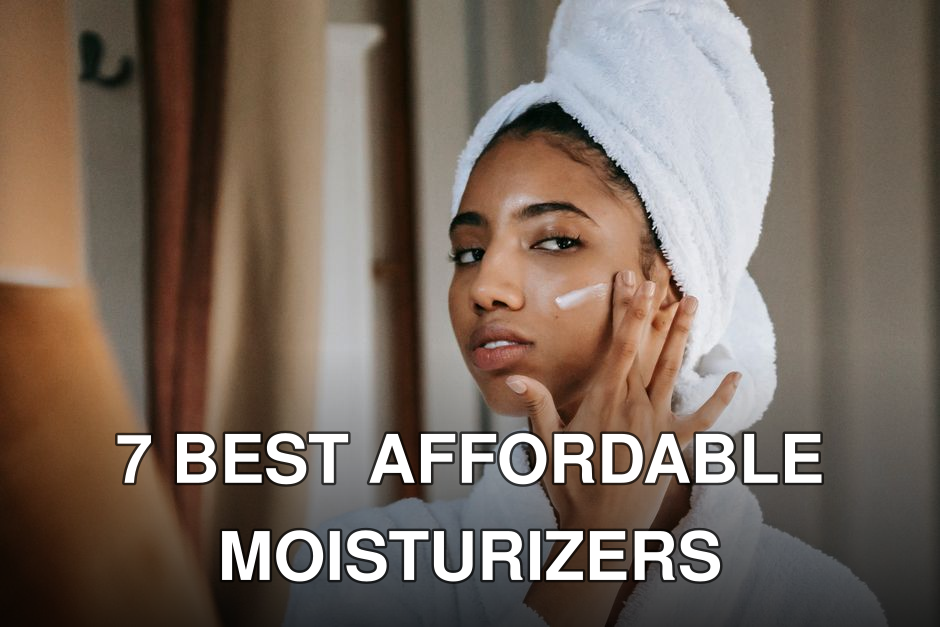 Young attentive ethnic female in bathrobe applying smear of moisturizing cream on face while looking in mirror at home