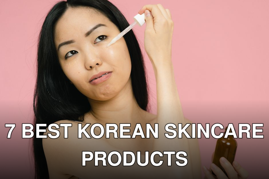 Asian woman applying skincare serum, holding a bottle against a pink backdrop indoors.