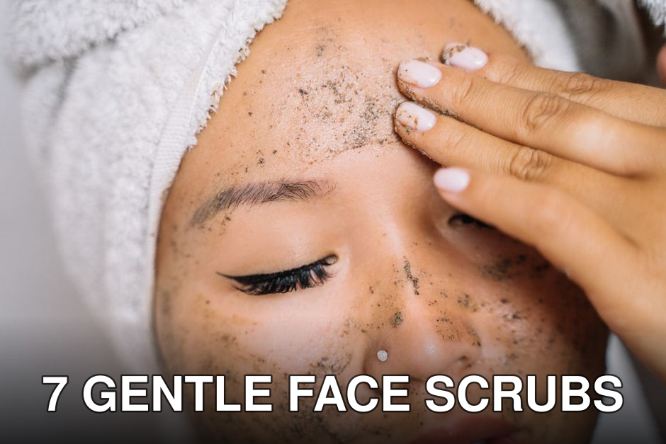 Woman with a head towel applying facial scrub for skincare routine.