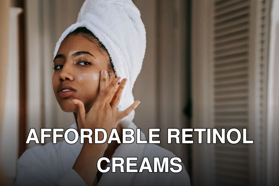 Young ethnic female in robe with terry towel on head applying moisturizing cream on face while looking in mirror in house