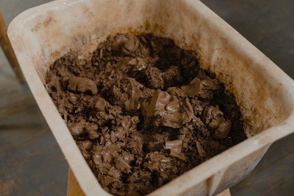 A detailed view of wet clay inside a large plastic container, ideal for pottery or sculpture.