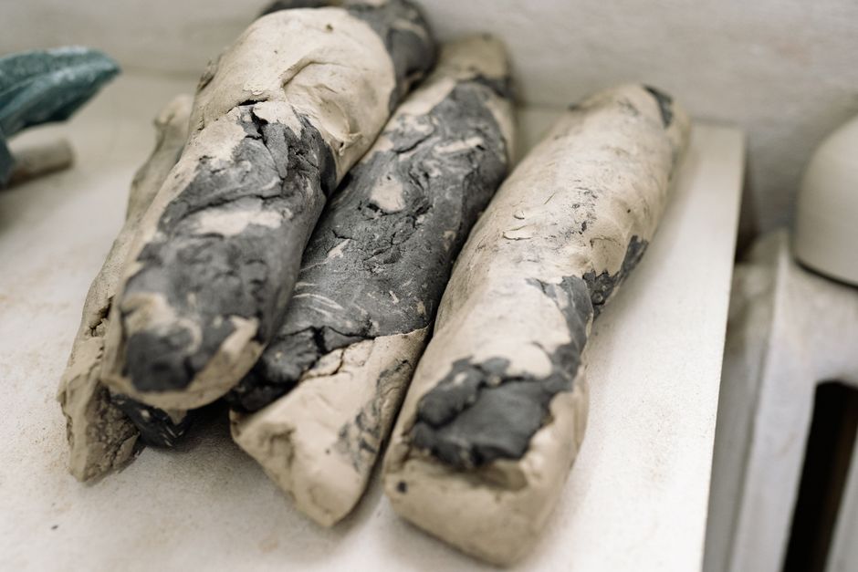 Detailed close-up of raw sculptor's clay pieces on a workbench showcasing texture.