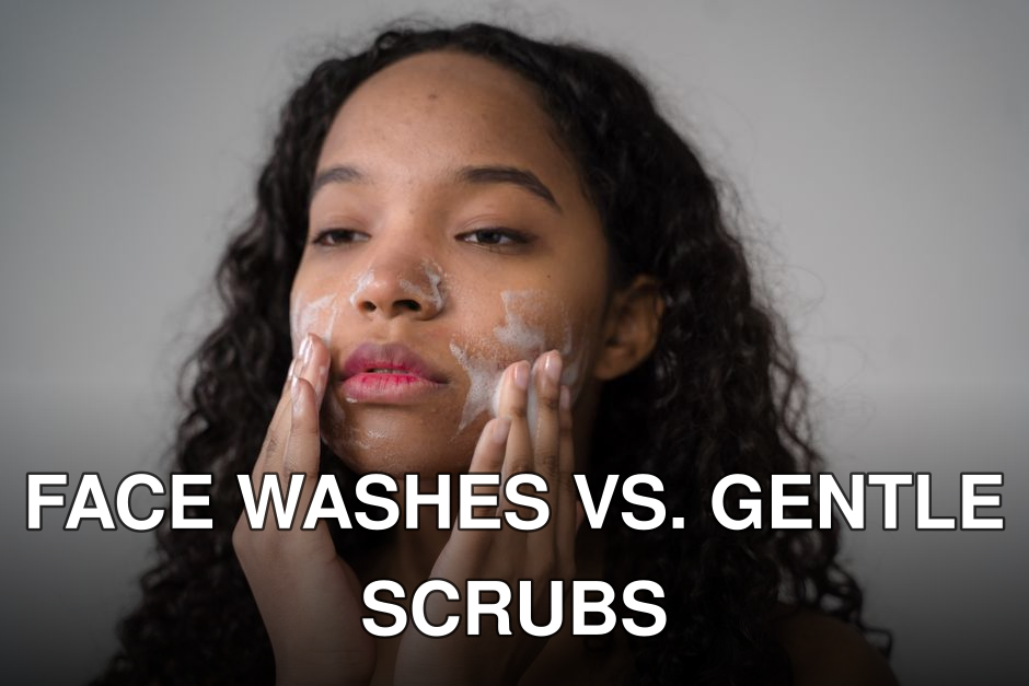African American female with long dark curly hair washing cheeks with facial foam on gray background