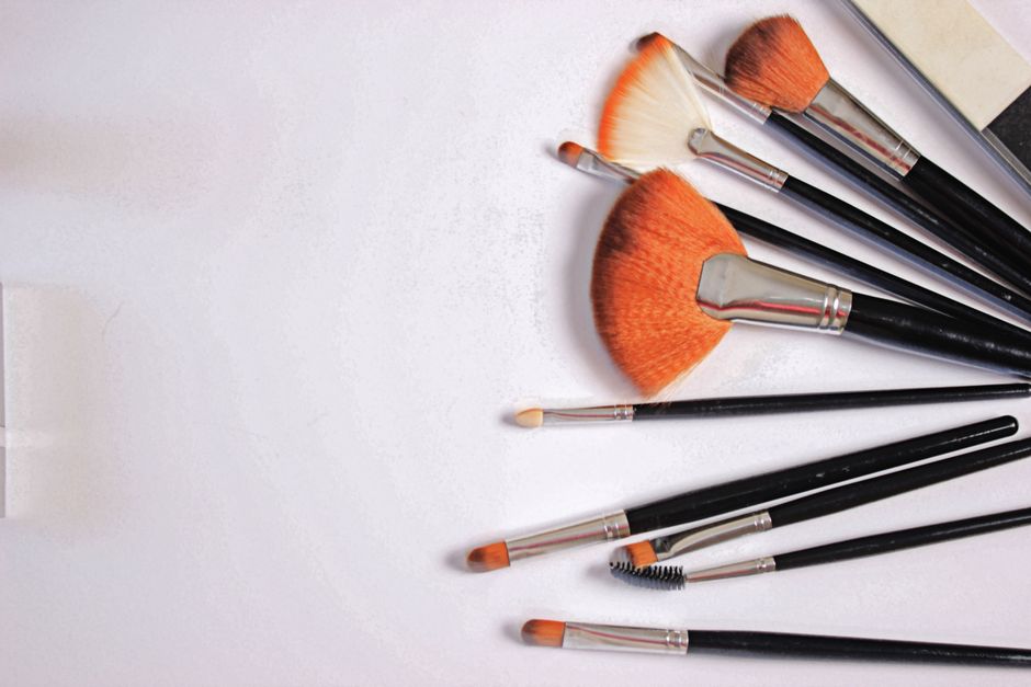 A collection of various makeup brushes arranged neatly on a white surface.