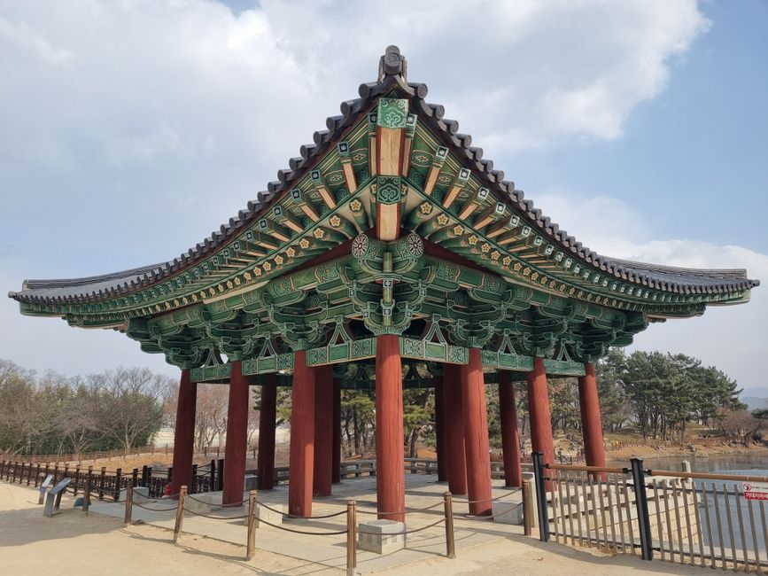 A traditional Korean pavilion in a serene outdoor setting on a sunny day.