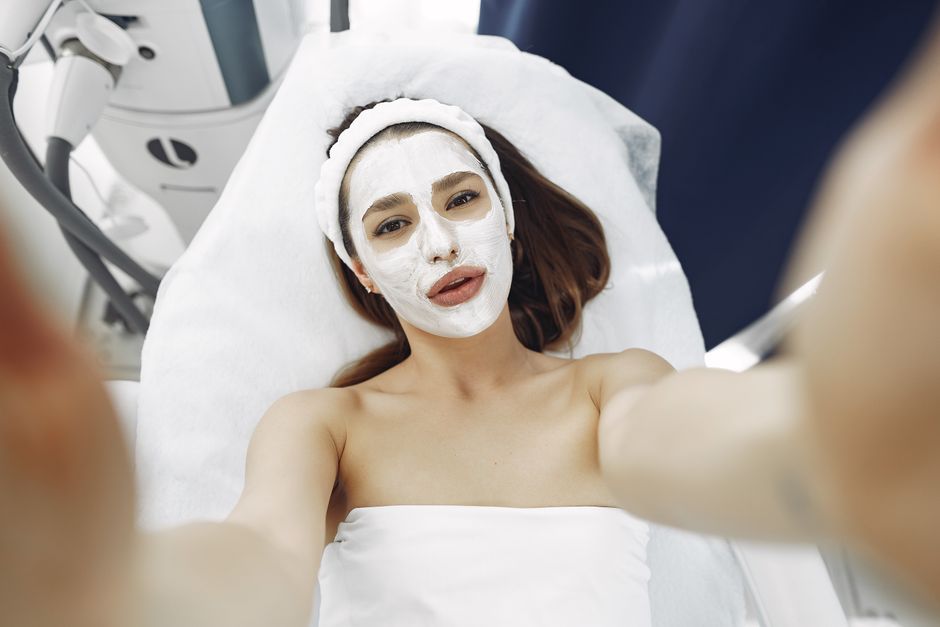 A woman enjoys a relaxing spa facial treatment with a moisturizing mask indoors. Perfect for wellness and skincare concepts.