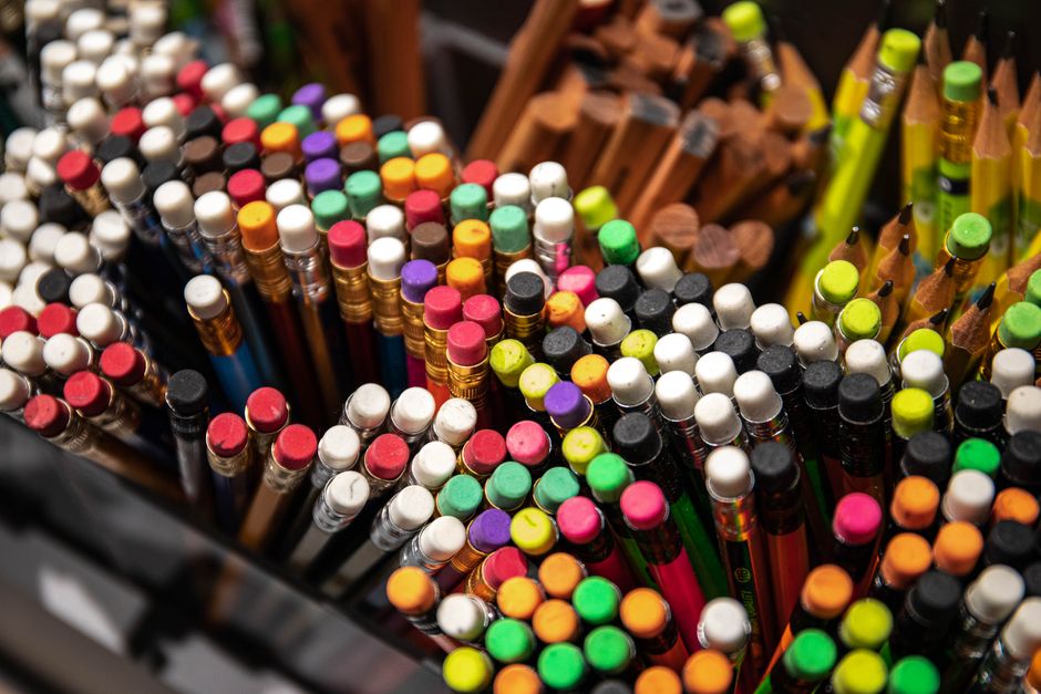 A vibrant collection of pencils with erasers viewed from above, showcasing creativity.