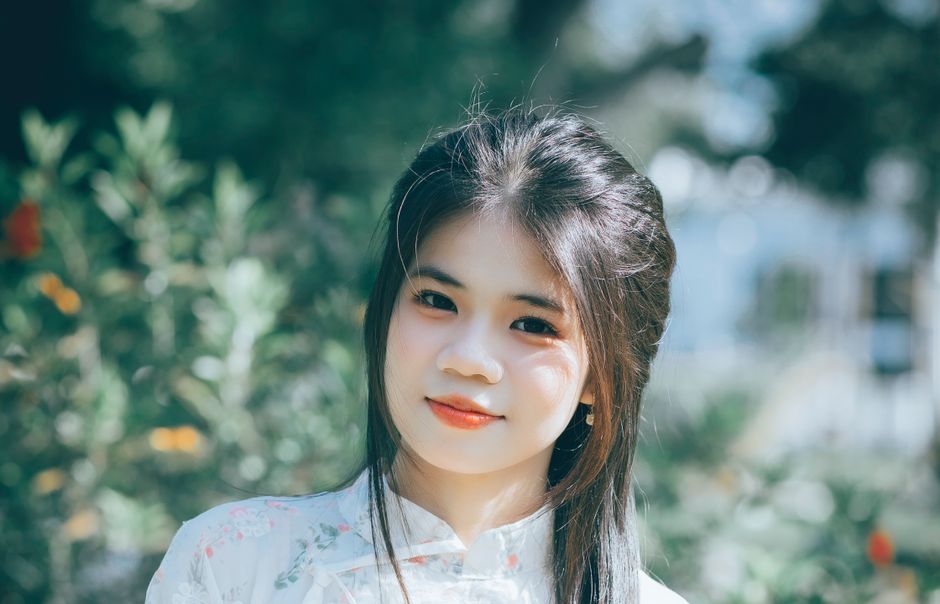 Portrait of a young woman with soft natural lighting in a serene outdoor setting.