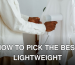 A man uses a steam iron to remove wrinkles from a white shirt hanging on a rack indoors.