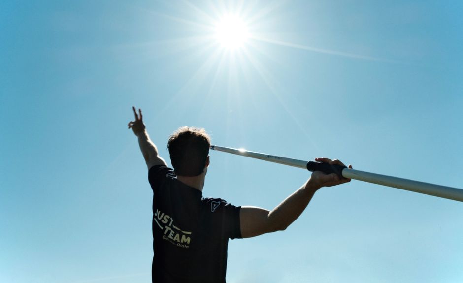 A pole vaulter reaching towards the sun, symbolizing determination and athleticism outdoors.