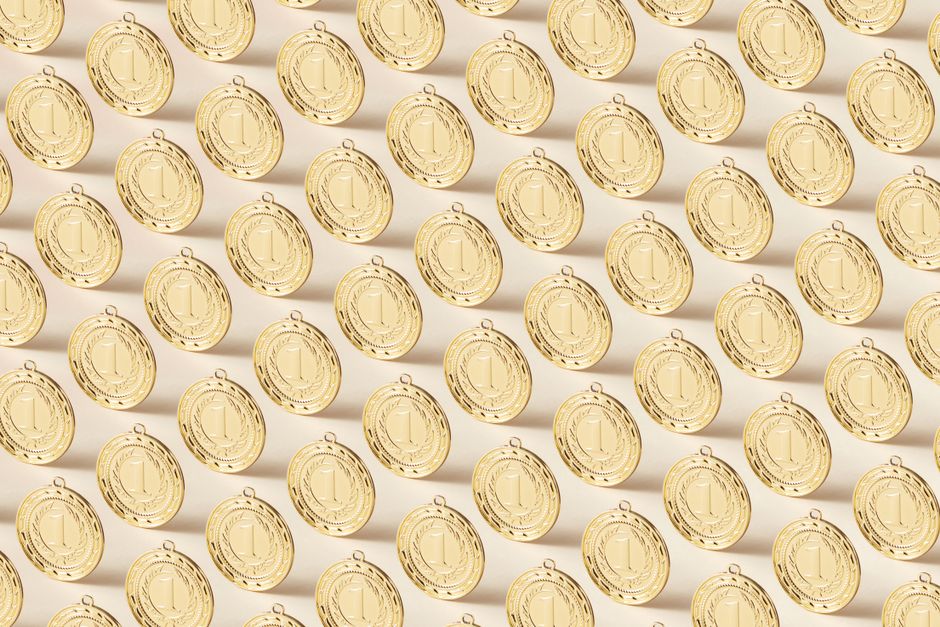 Seamless pattern featuring gold medals on a flat background, ideal for sports themes.