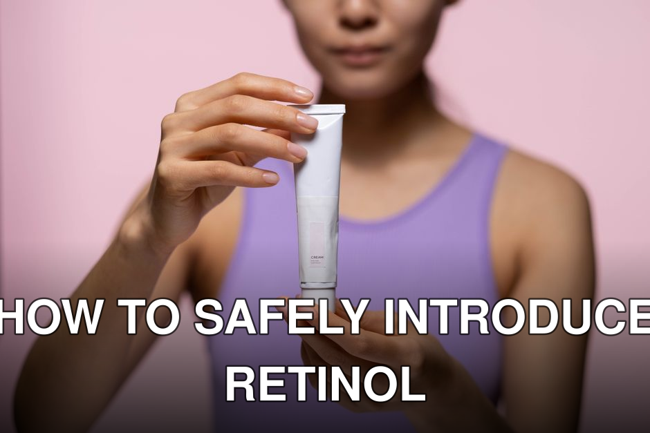 A woman in a purple tank top holds a skincare cream against a pink background in a studio setting.