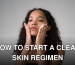 A young woman with curly hair gently applies skincare cream to her face.