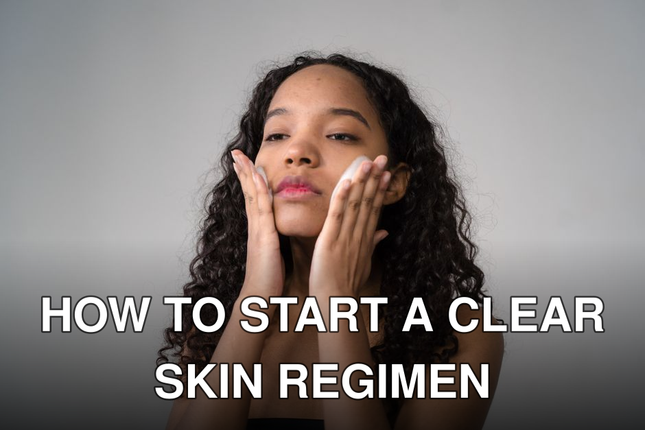 A young woman with curly hair gently applies skincare cream to her face.