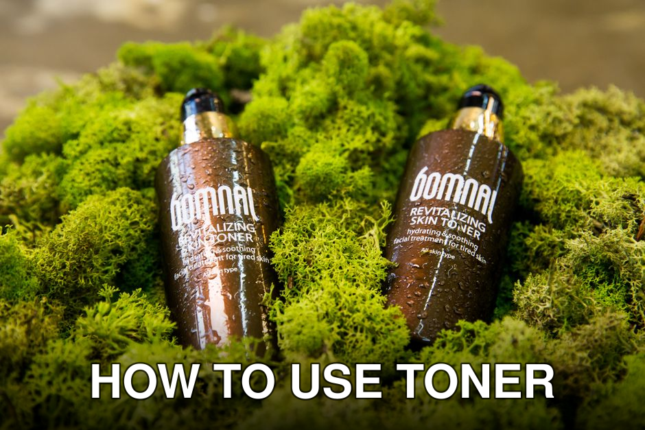 Close-up of Bomnal skincare bottles with waterdrops on a mossy surface, creating a natural look.