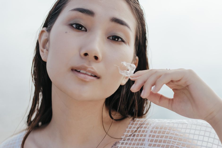 Close-up portrait of an Asian woman outdoors, exuding calm and elegance.