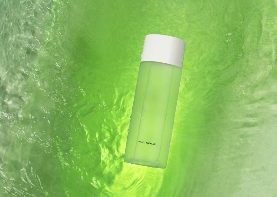 A green-tinted bottle floating on a swirling vibrant green liquid background, evoking freshness.