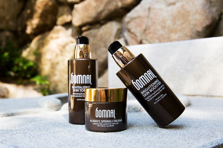 High-end skincare products displayed outdoors, featuring revitalizing toner and brightening booster.