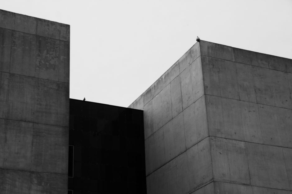 Minimalist black and white photo of brutalist concrete buildings with clean lines.