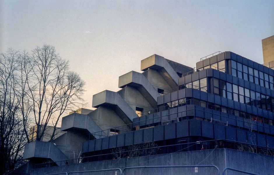 A striking example of modern brutalist architecture captured during sunset, featuring geometric lines and stark concrete.