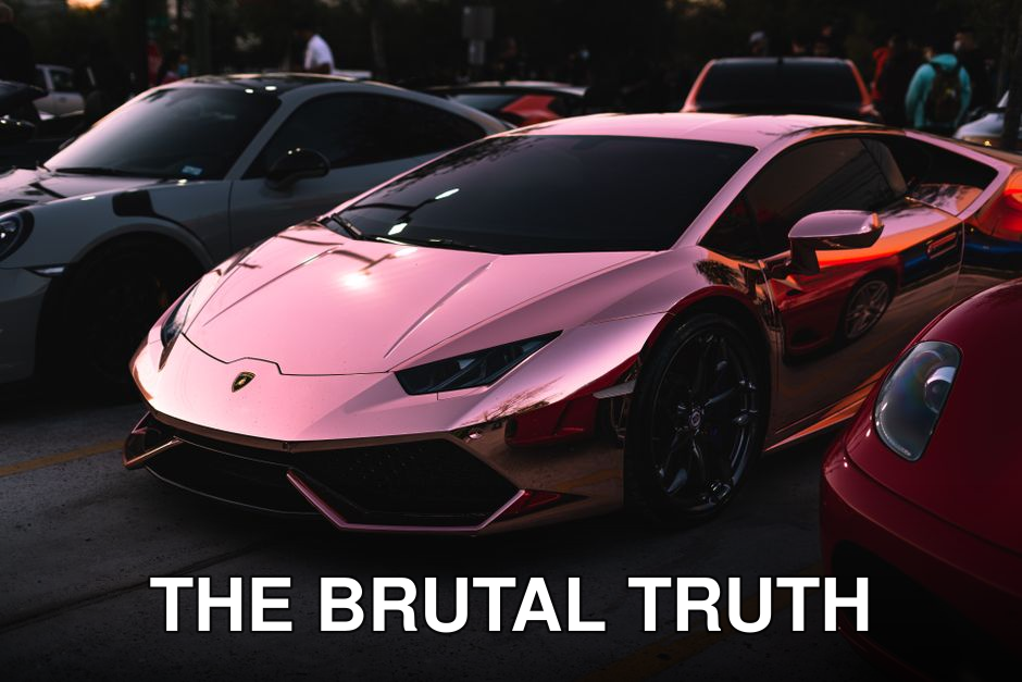 Sleek rose gold Lamborghini shining at an outdoor car show, epitome of luxury and power.