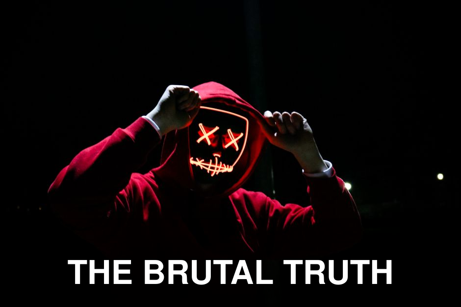 A spooky illuminated mask figure with a red hoodie in a dark setting, perfect for Halloween themes.