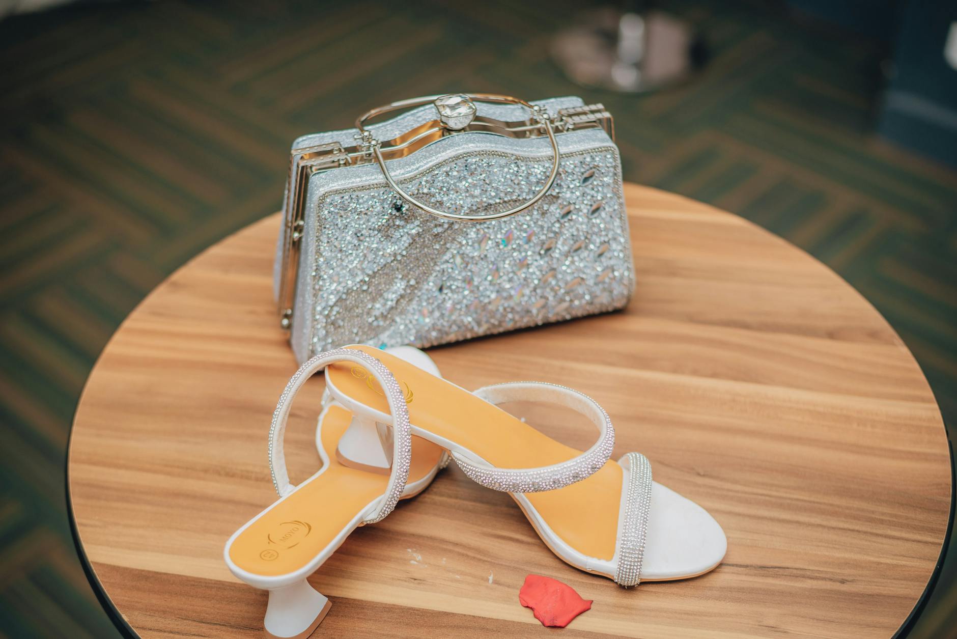 Stylish bridal shoe and sparkling clutch on a wooden table, Nairobi wedding.