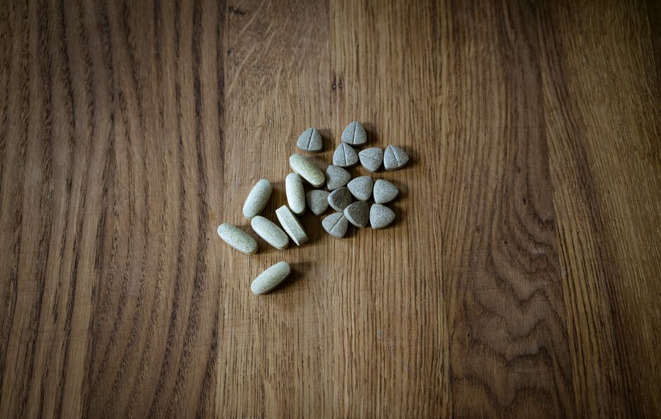 From above of set of different assorted medical pills arranged on lumber surface