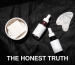 High-angle view of skincare products including serums, gua sha, and bar soap on a dark fabric backdrop.