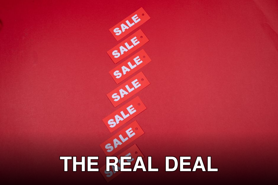 Top view of red sale tags arranged on a vibrant red background for commercial use.