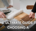 Hands selecting and comparing textile and wood samples for interior design.