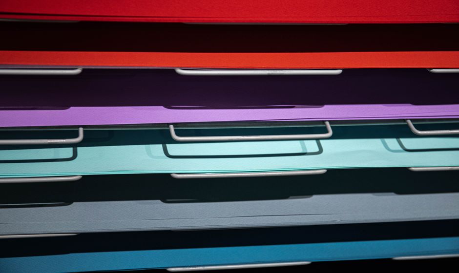Stacked colorful papers in an art studio, perfect for craft projects.