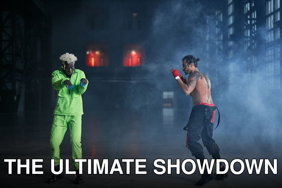 Two martial artists engage in a dynamic showdown amidst dramatic smoke on stage.