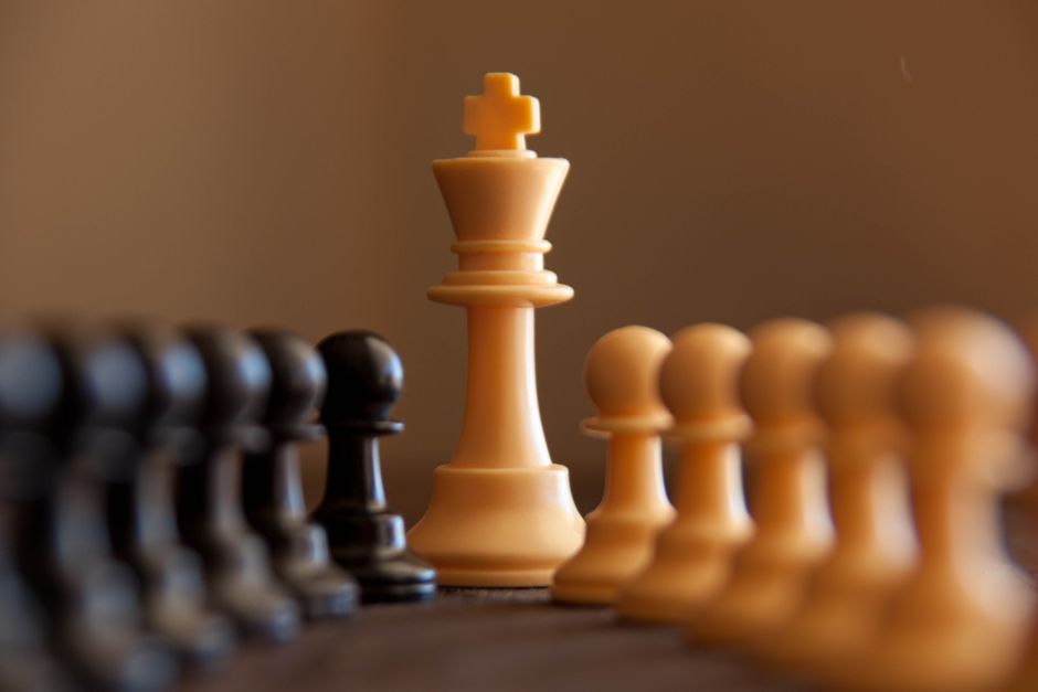 Close-up of chess pieces with king in focus, highlighting strategy and competition.