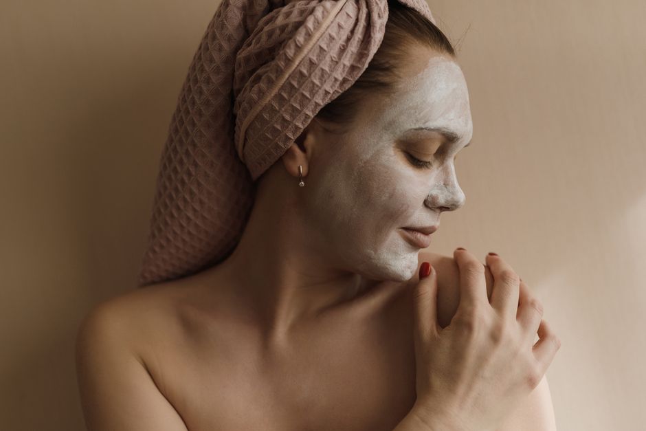 Woman enjoying a serene skincare moment, applying a soothing facial mask.