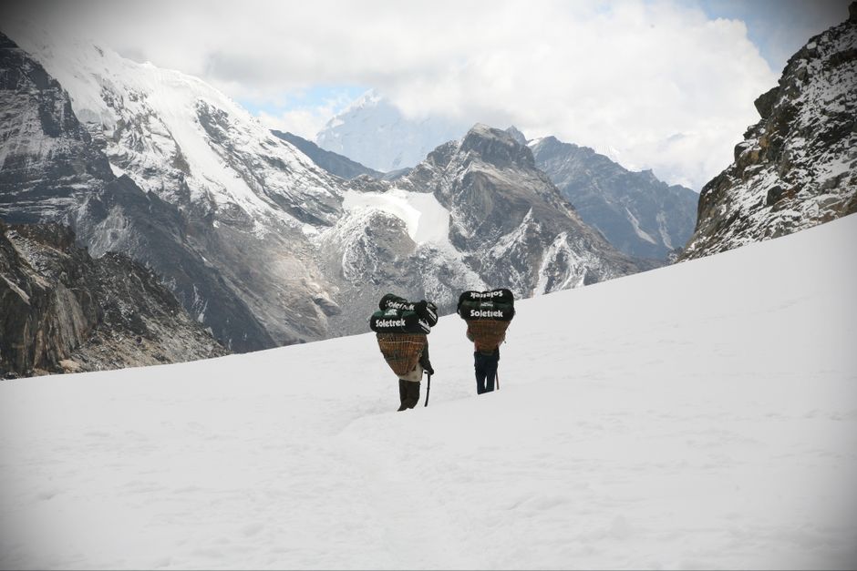 Two trekkers navigating snowy terrain in the majestic Himalayas.