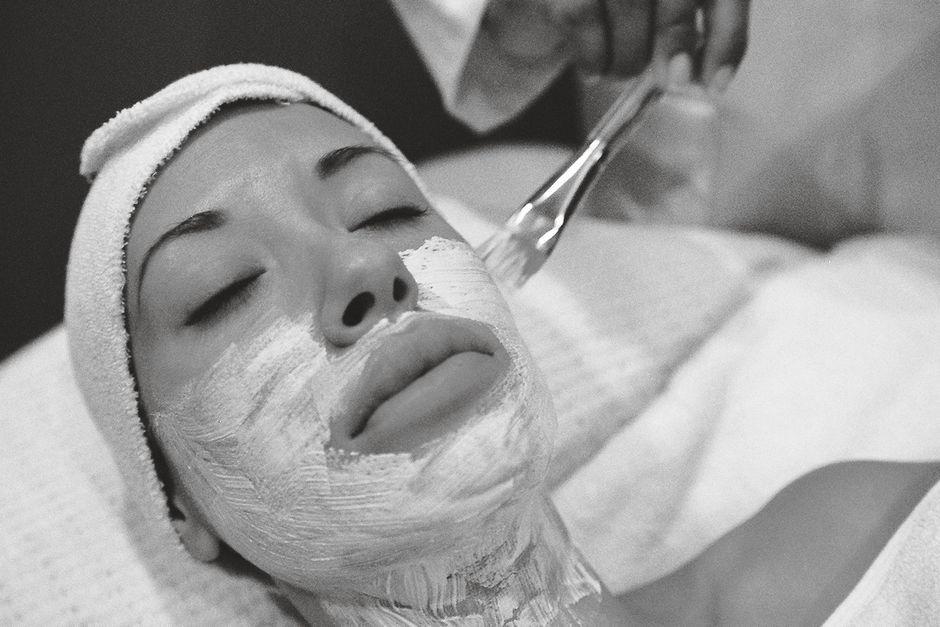 Close-up of a woman receiving a calming facial mask in a spa setting.
