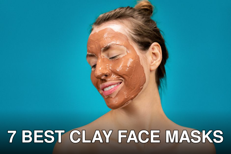 A woman smiles while applying a clay mud mask for skincare treatment.