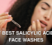 A woman's hand holding a dropper with serum against a blurred face.