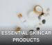 A flat lay of skincare bottles and jars with stones on a white background.