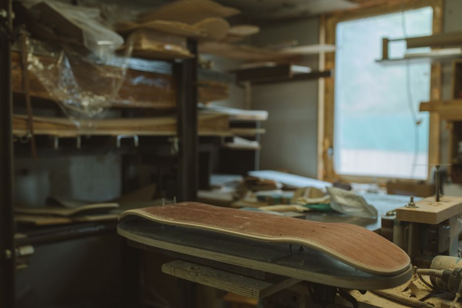 A glimpse into the detailed crafting process in a wooden skateboard workshop.