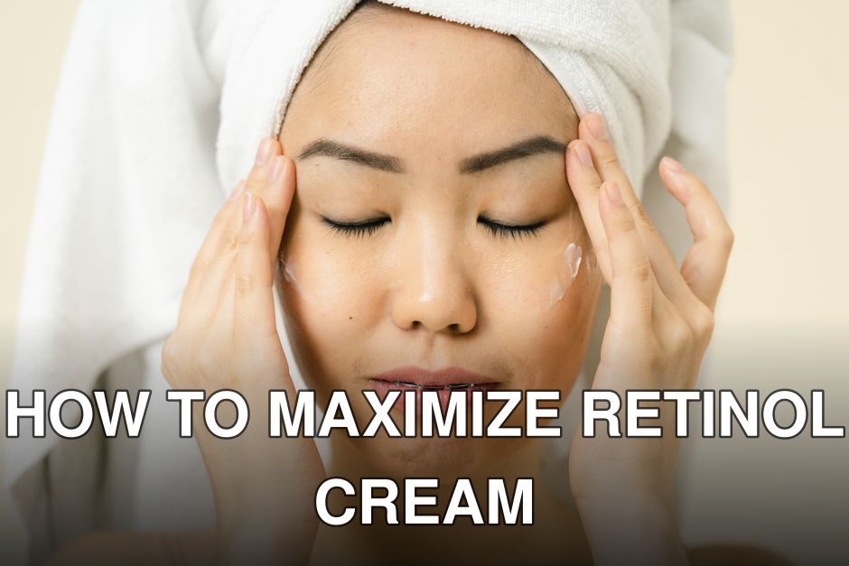 Asian woman with a towel on head applying moisturizer for skincare routine.