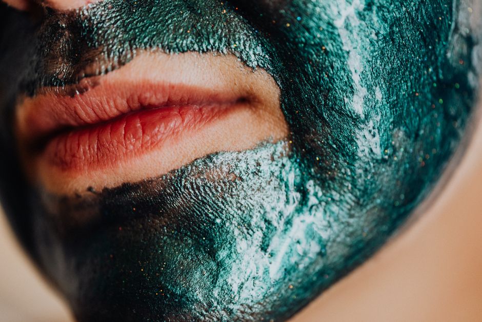 A detailed close-up shot of lips with a green facial mask applied.