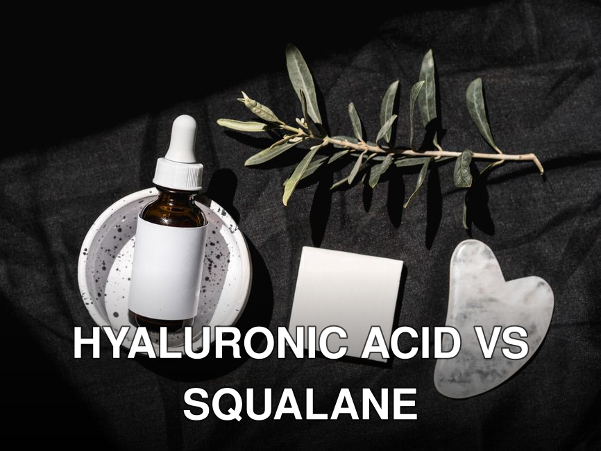 Elegant beauty product arrangement featuring a serum dropper bottle and gua sha on a black background.