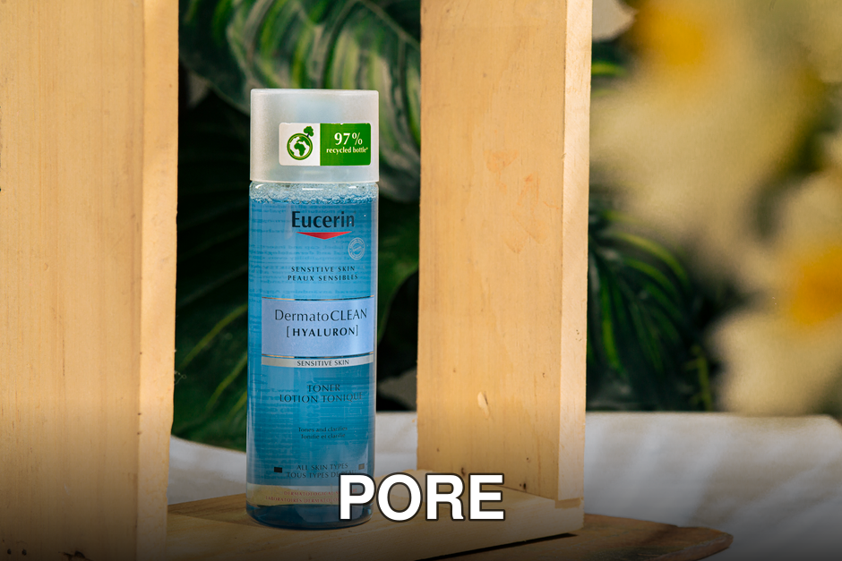 Eucerin DermatoCLEAN Hyaluron toner bottle surrounded by wooden frame and plants.