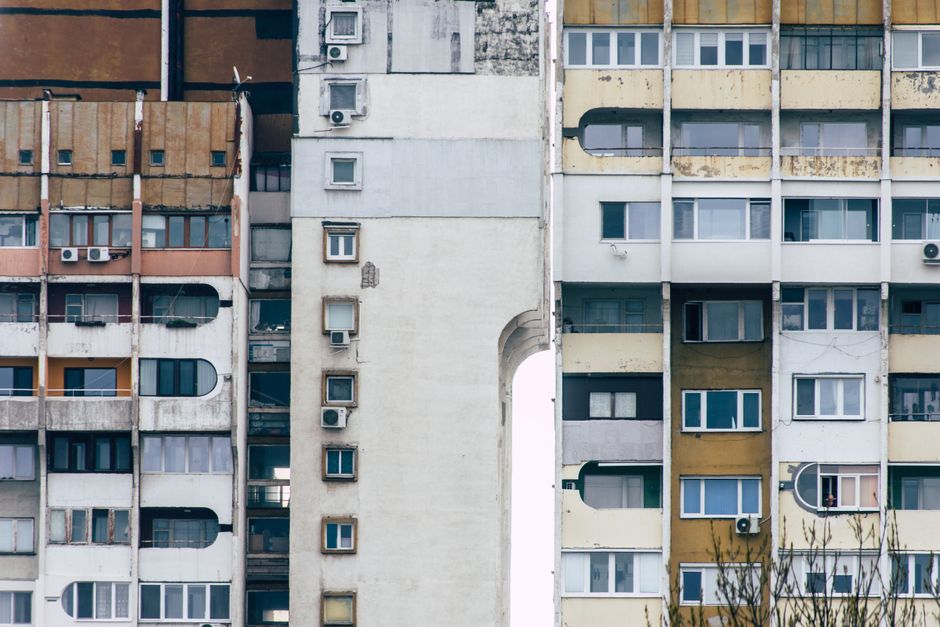 Detailed view of Soviet-style concrete apartment buildings with weathered facades and air conditioning units.