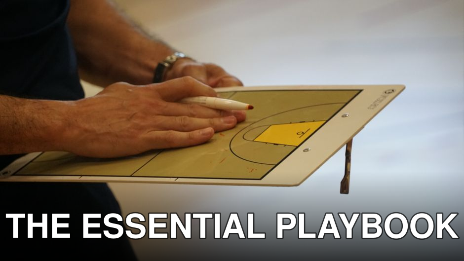 Close-up of a coach using a basketball tactics board to plan game strategy indoors.