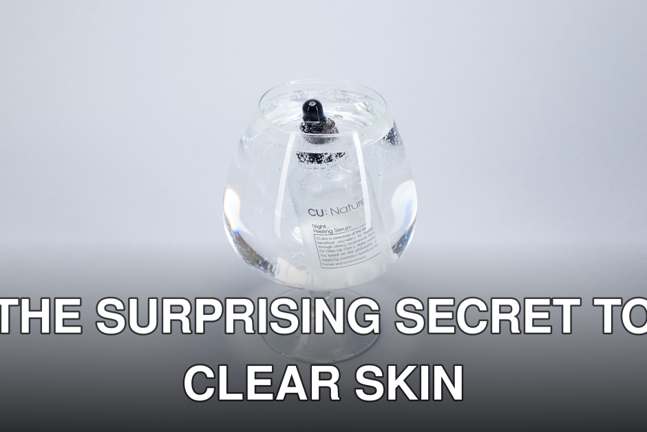 A serum bottle submerged in a wine glass filled with water, highlighting purity and clarity.